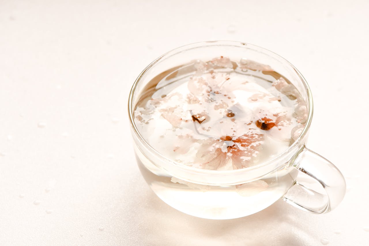 about-02 A serene view of sakura flower tea in a clear glass, perfect for relaxation and mindfulness.